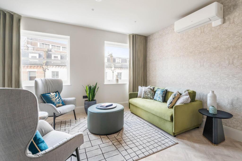 a living room with a green couch and chairs at Kentish Town Road in London