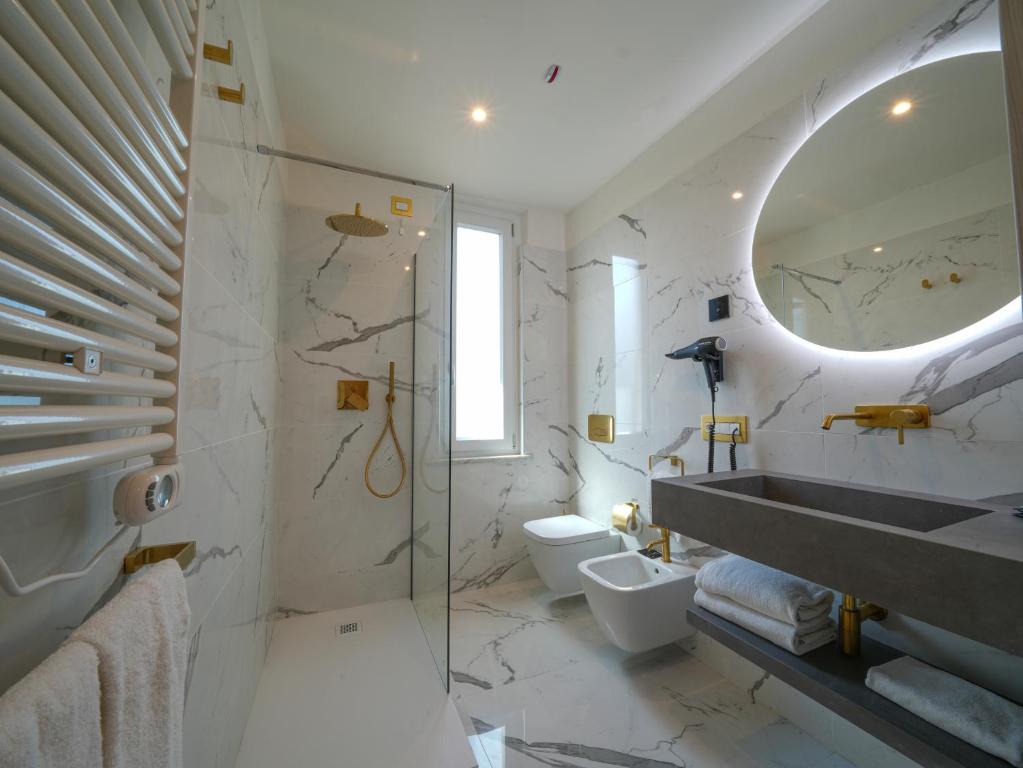 a bathroom with a sink and a toilet and a mirror at Castiglioncello Suite in Castiglioncello