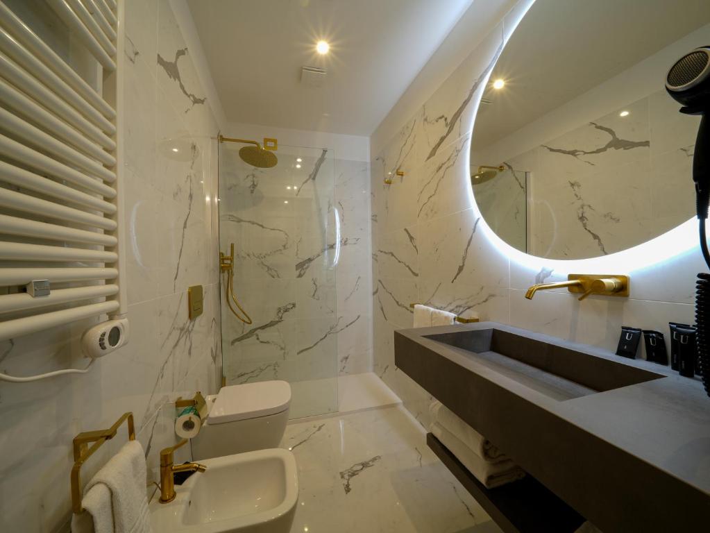 a bathroom with a sink and a toilet and a mirror at Castiglioncello Suite in Castiglioncello