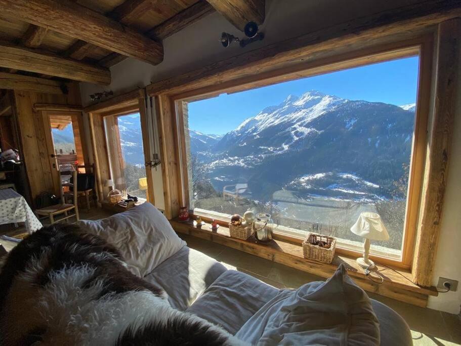 a room with a large window with a mountain view at La Rosière Magnifique chalet savoyard 160 m2 T5 in Montvalezan