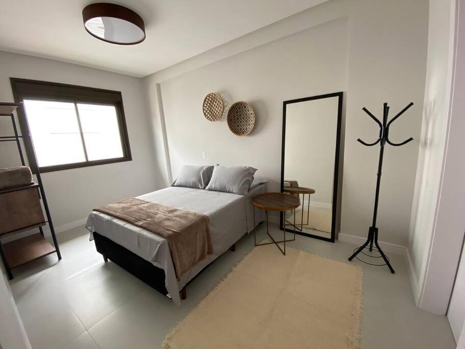 En eller flere senge i et værelse på Apto Novo Bombinhas - UMA QUADRA DO MAR!