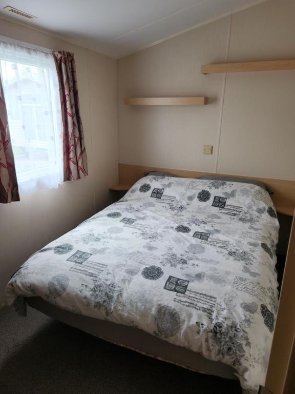 una camera da letto con un letto coperto di Sam's Caravan Hire Coastfield Holiday Village Ingoldmells a Ingoldmells