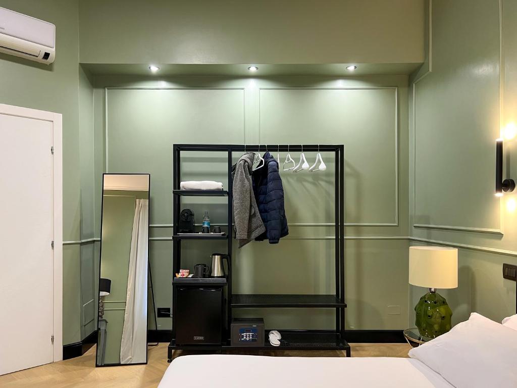 ein Schlafzimmer mit einer grünen Wand, einem Schrank und einem Bett in der Unterkunft Mondo7 in Bologna