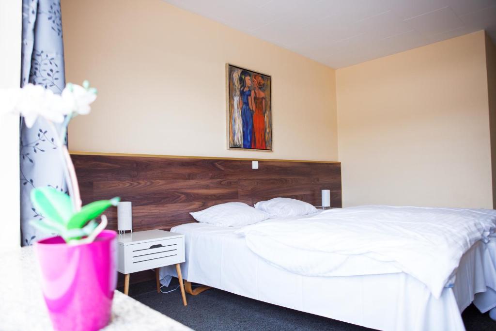 um quarto com uma cama branca e uma cabeceira em madeira em Gæstehus em Grasten