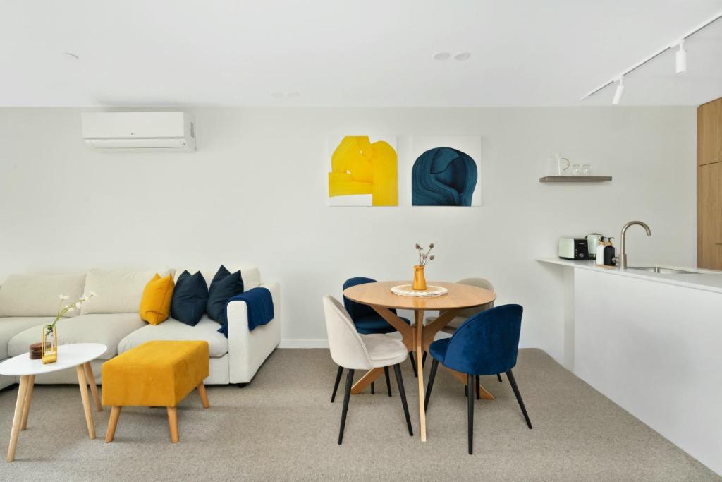 a living room with a couch and a table and chairs at Kashmir, Modern and luxury 2BR 2BA, Fast WiFi & Netflix, Free Parking, Central Location, near CBD in Canberra
