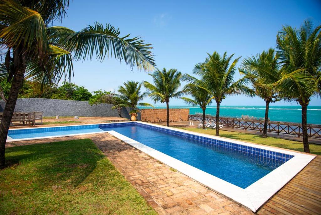 a swimming pool with a view of the ocean at Villa Patara in Marechal Deodoro