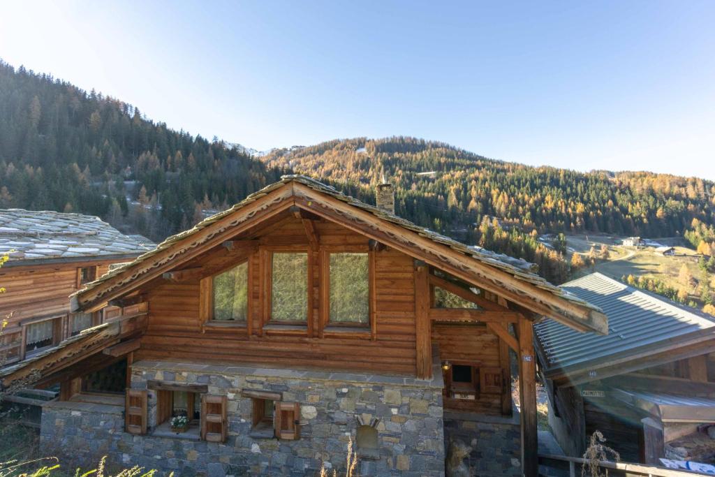 a log cabin with a mountain in the background at les ours in La Plagne Tarentaise