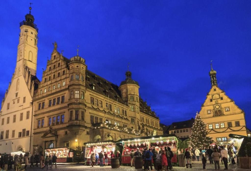un gran edificio con un mercado de Navidad delante de él en Pension Birgit, en Rothenburg ob der Tauber