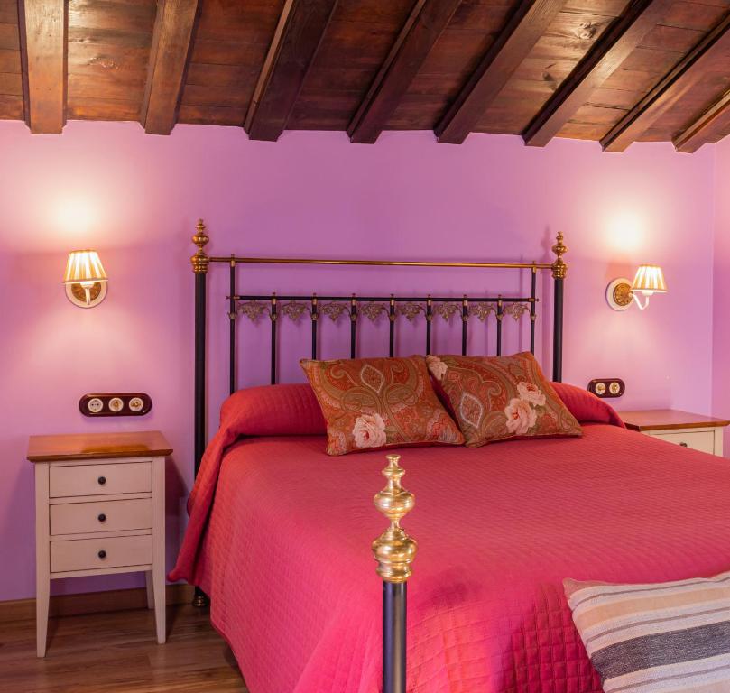 エルバスにあるLa Atalayaの紫の壁のベッドルーム1室、赤いベッドカバー付きのベッド1台が備わります。