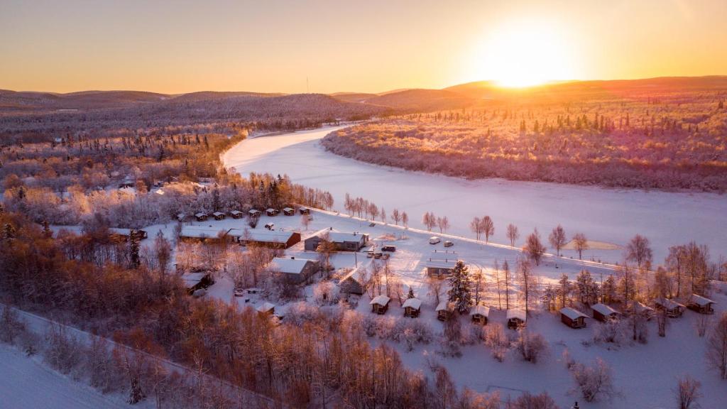 - une vue aérienne sur un complexe dans la neige à côté d'une rivière dans l'établissement Arctic River Resort, à Ivalo