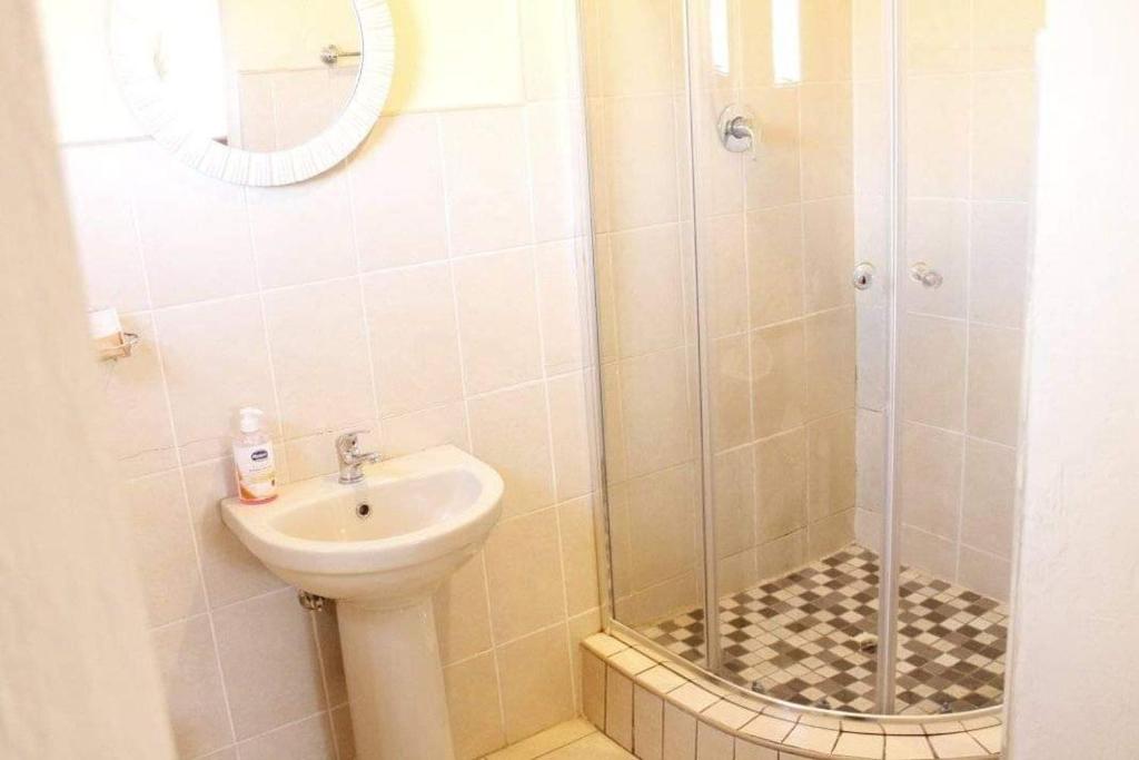 a bathroom with a sink and a shower at RIO GUESTHOUSE in Maseru