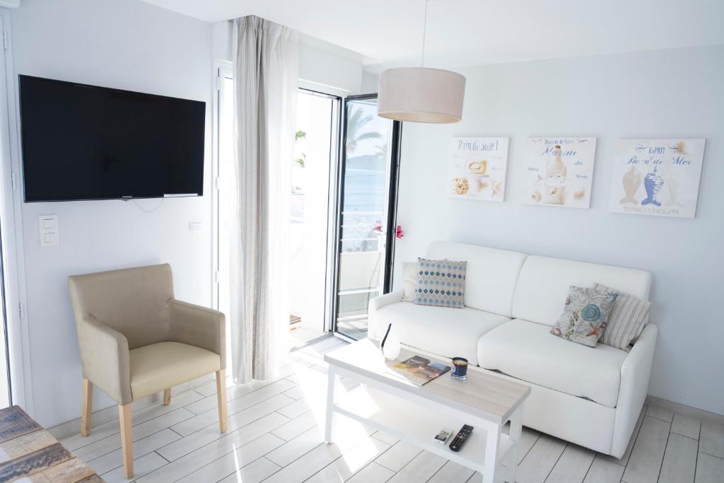 - un salon avec un canapé blanc et une chaise dans l'établissement Hotel La Ciotat - A deux pas de l'eau, à La Ciotat
