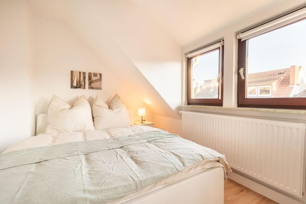 a white bedroom with a large bed and a window at Sehr schöne Wohnung für 6 Pers. in Bremen