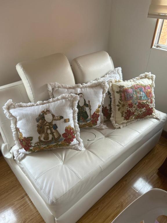 a white couch with pillows on it at Villadorado in Bogotá