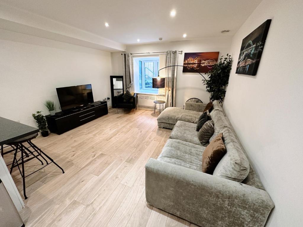 a living room with a couch and a television at Newcastle Quayside - Sleeps 8 - Central Location - Parking Space Included in Newcastle upon Tyne