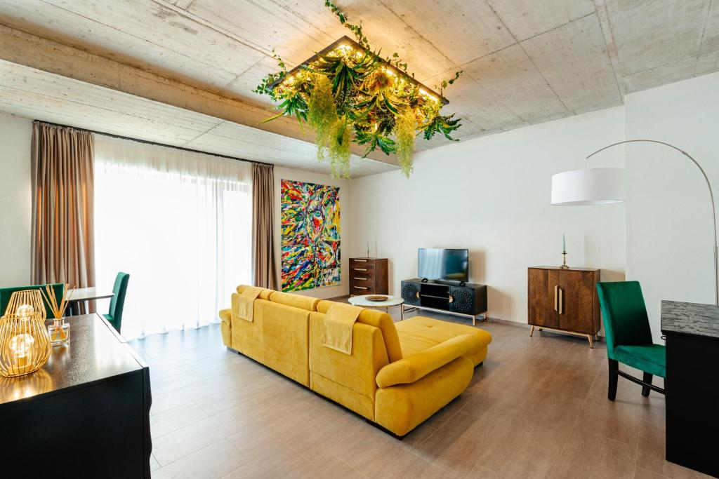 a living room with a yellow couch and a television at Centro Accommodation in Cluj-Napoca