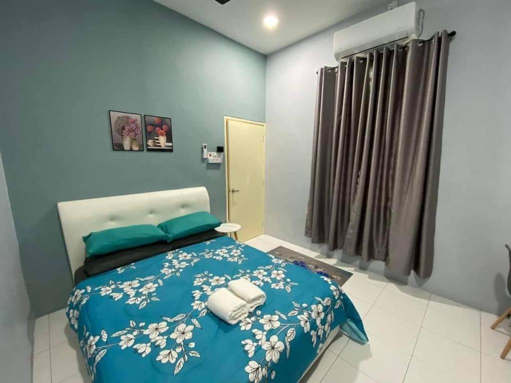 Schlafzimmer mit einem Bett mit blauer Decke in der Unterkunft MS HOMESTAY in Arau