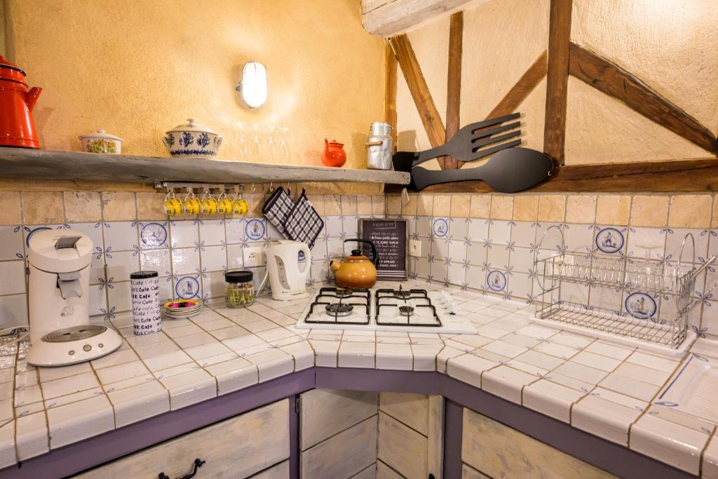 a kitchen with a white tiled counter top at Gîte Les Toisnières in Marigné-Laillé