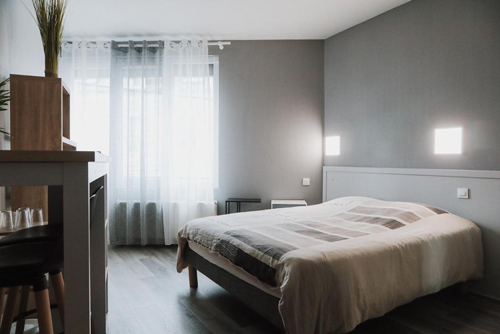 um quarto com uma cama, uma secretária e uma janela em Studio centre ville Bourges em Bourges