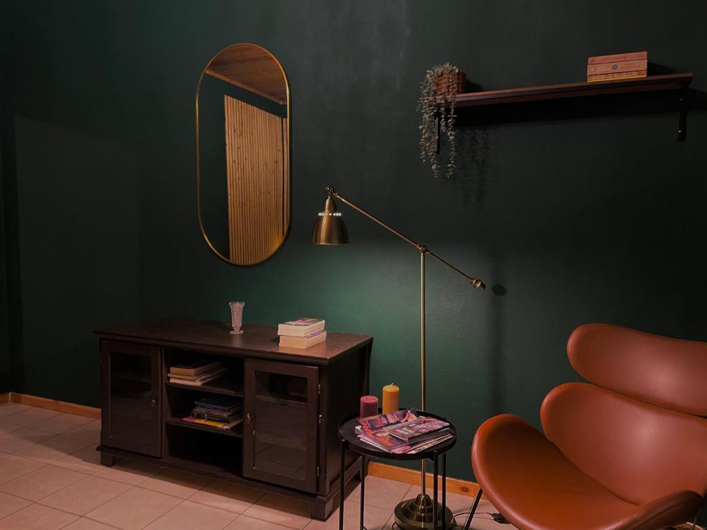 a green room with a chair and a mirror at Loukia's Place in Vitina