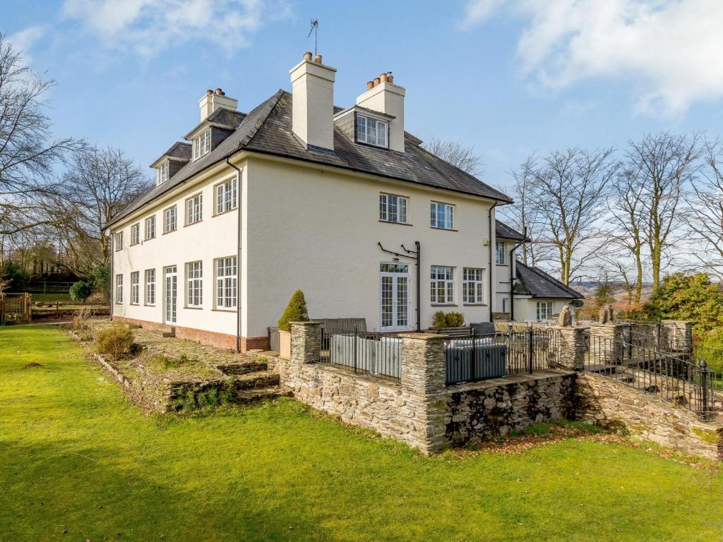 a large white house with a stone wall at 7 bed in Exford MONKH in Exford