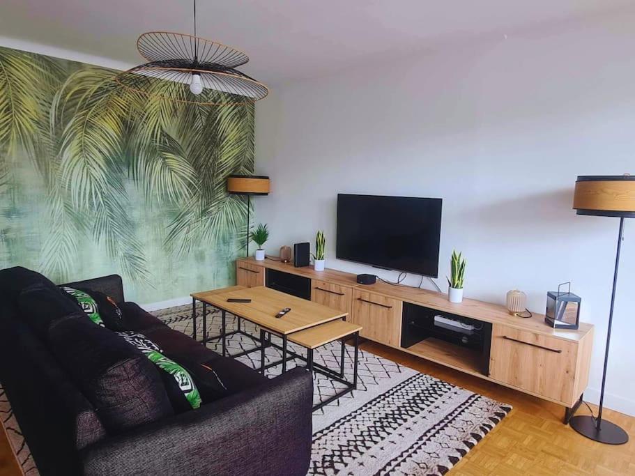 a living room with a couch and a flat screen tv at T4 proche de tout ! Séjour parfait garanti in Saint-Herblain