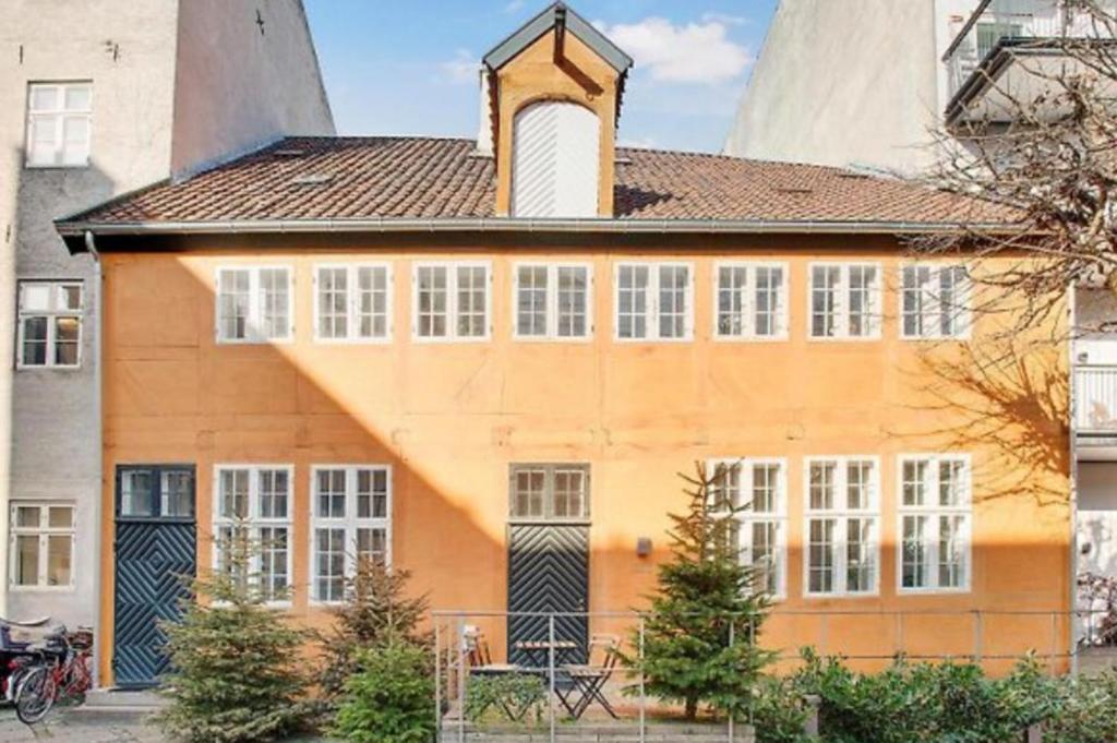 an orange building with a clock tower on top of it at ApartmentInCopenhagen Apartment 1577 in Copenhagen