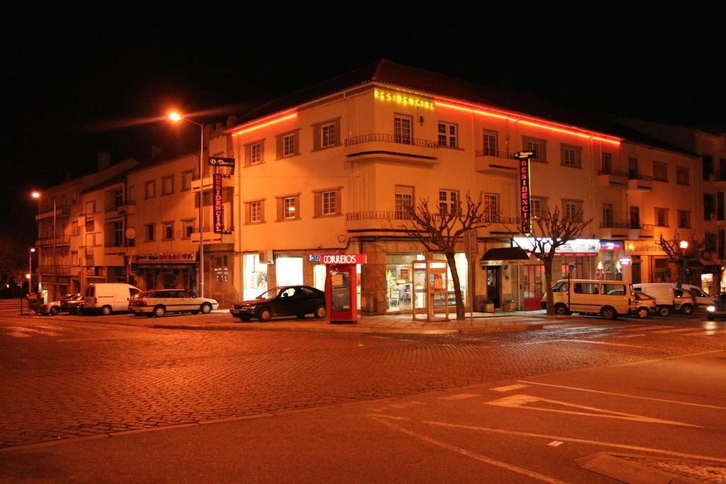 un bâtiment dans une rue la nuit avec des voitures garées à l'extérieur dans l'établissement Residencial Dom Duarte, à Viseu