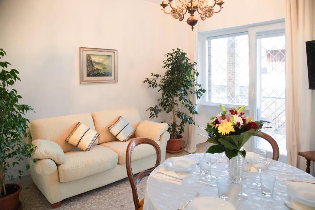 een woonkamer met een bank en een tafel bij AURELIA LORIS HOUSE in Rome