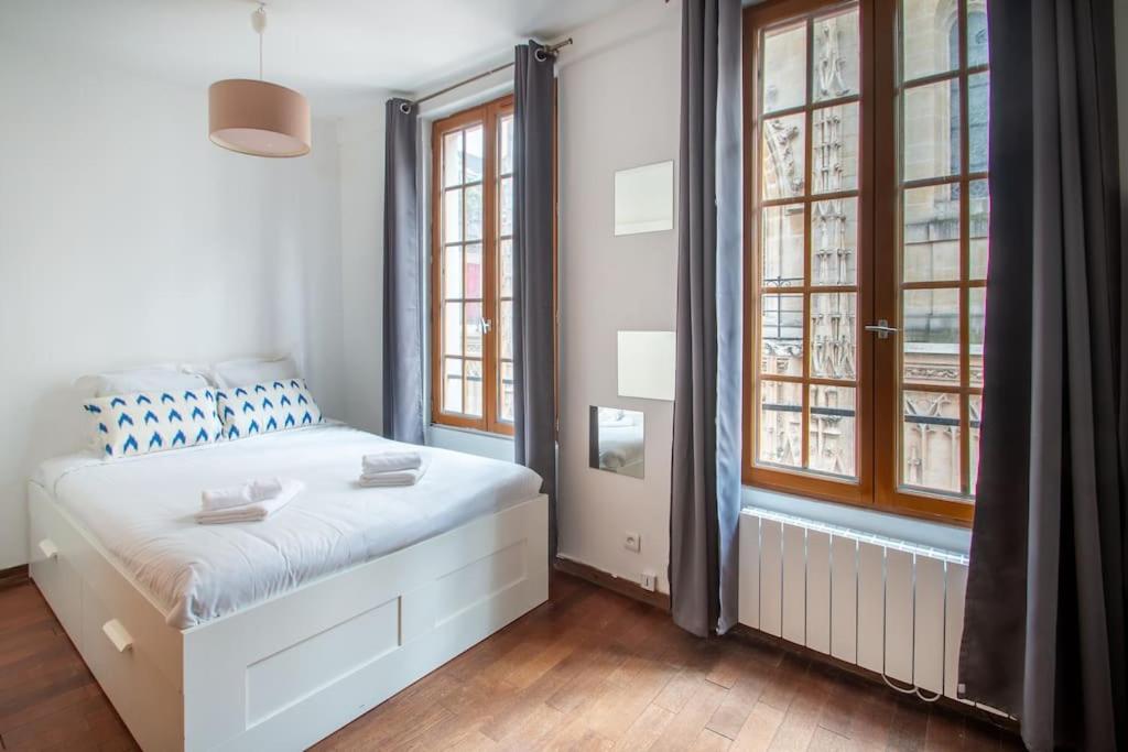 - une chambre avec un lit blanc et 2 fenêtres dans l'établissement Studio au cœur du Marais - II, à Paris