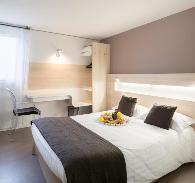Un dormitorio con una cama con un plato de fruta. en Hotel Restaurant l'Eskemm St Brieuc-Trégueux, en Tregueux