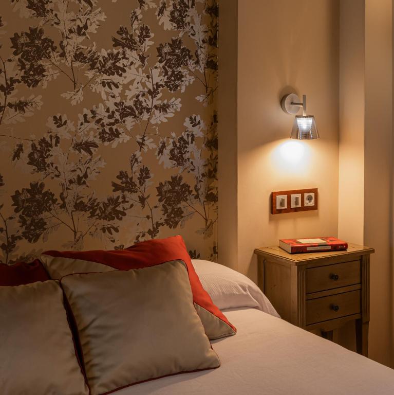 a bedroom with a bed with a flowery wallpaper at El Romero in Hervás