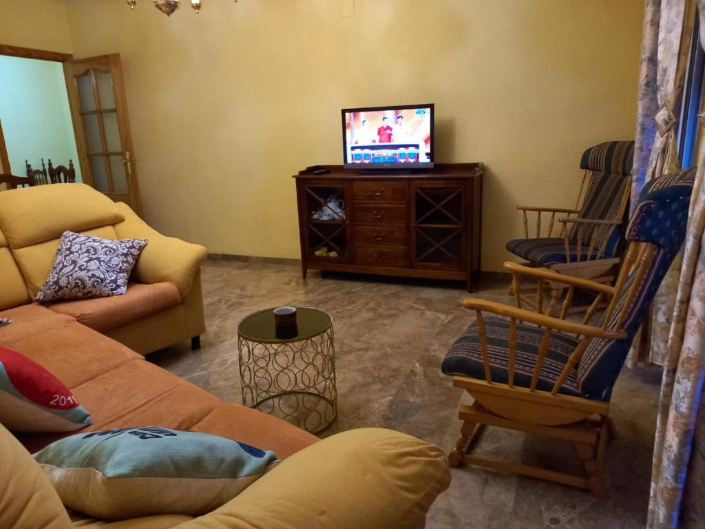 a living room with a couch and a tv at Welcoming house with mountain view in Cazorla in Cazorla