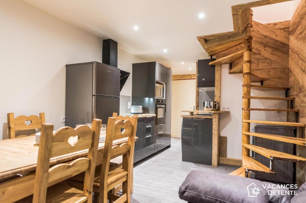 une cuisine et une salle à manger avec une table et des chaises en bois dans l'établissement Val Thorens Appartement 8 personnes aux pieds des pistes, à Val Thorens