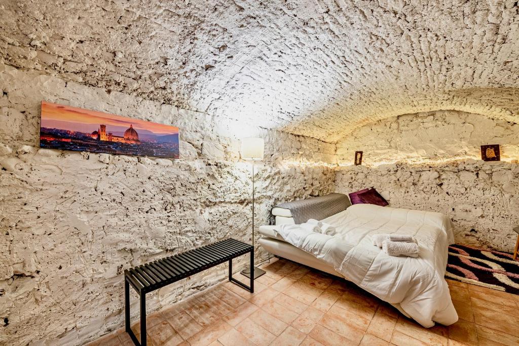 una camera con un letto in una parete in pietra di "Florence Cave Central Suite" - 5 min To Mandela Forum - 2 Bedrooms - Free Parking a Firenze
