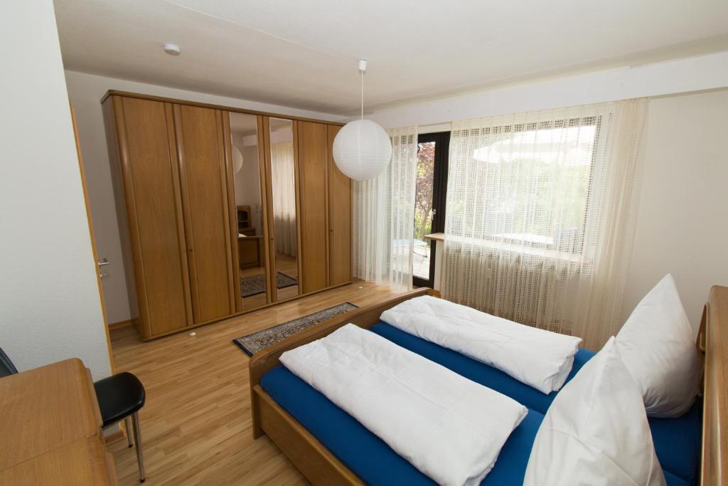 um quarto com uma cama azul e almofadas brancas em Ferienwohnung Auer em Stockach