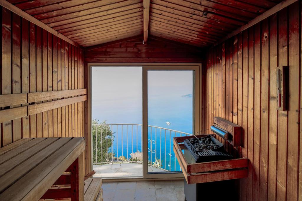 a room with a stove and a balcony with a window at La Chèvre d'Or in Éze