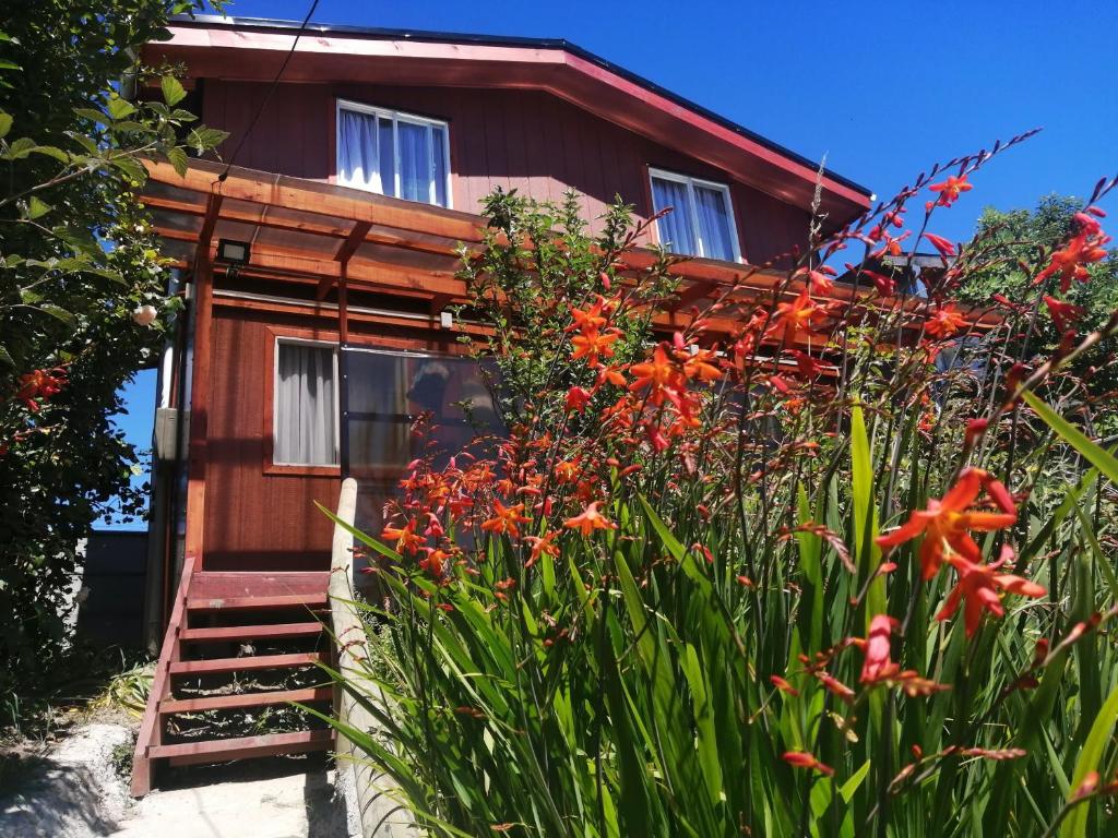 Una casa con un ramo de flores delante de ella. en Cabañas Los Geranios, en Osorno