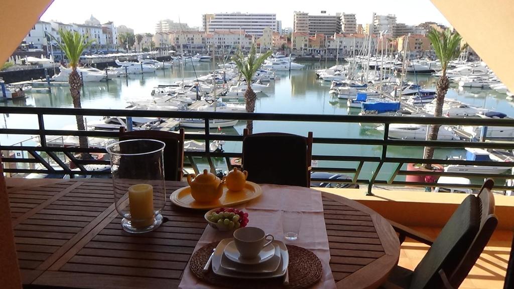 a table with a view of a marina with boats at Beach Apartment Marina Vilamoura in Vilamoura
