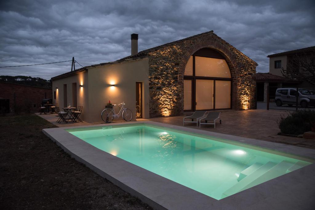 a swimming pool in front of a house at night at Mas Fidel Turisme in Llambillas