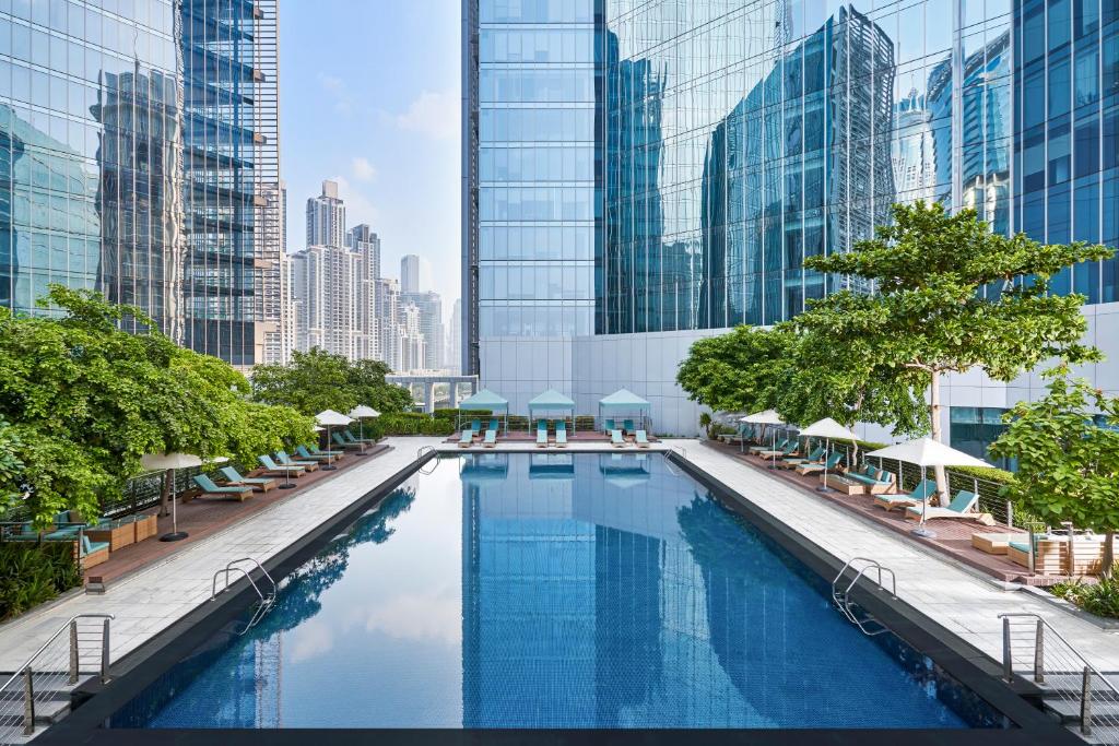 une grande piscine dans une ville avec de grands bâtiments dans l'établissement Anantara Downtown Dubai, à Dubaï