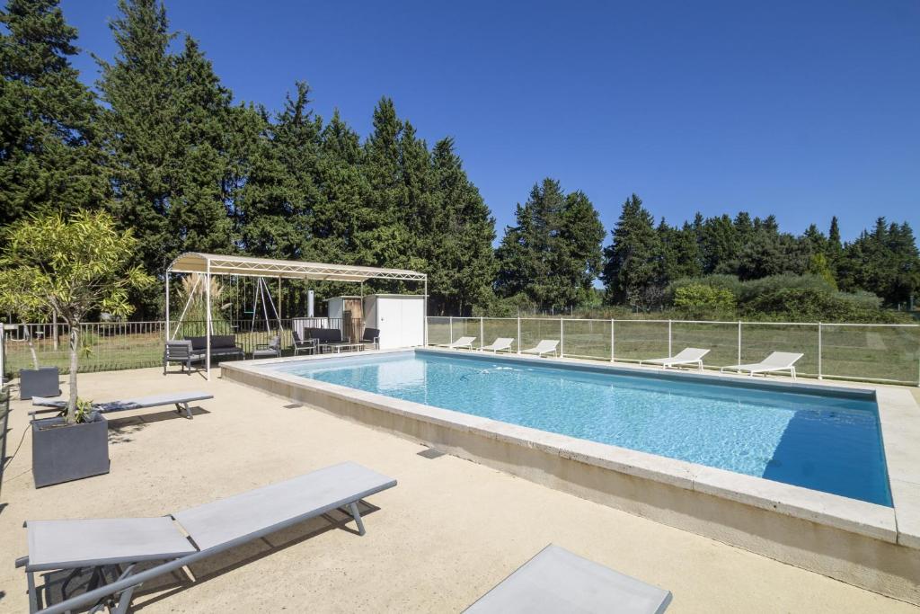 - une piscine avec deux chaises longues à côté d'une clôture dans l'établissement Maison Fontvieille, à Fontvieille