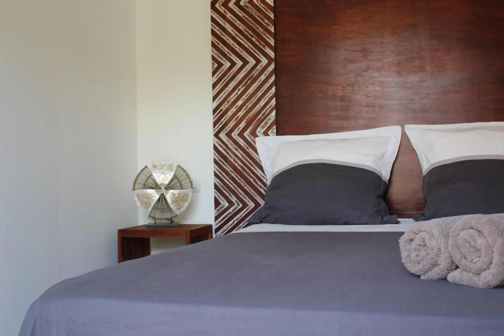 1 dormitorio con cama azul y cabecero de madera en Villa Piscine - Bougainvillier, en Les Anses-dʼArlet