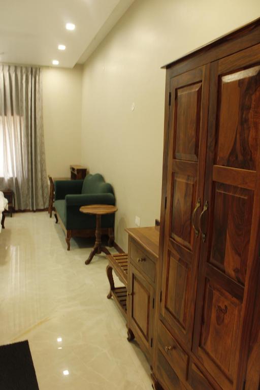 a living room with a wooden cabinet and a couch at Farm Aavjo in Pushkar