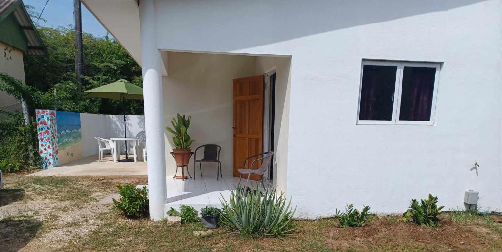 a white house with a patio and a table at Casa Aichi in Willemstad