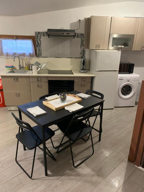 a kitchen with a black table and chairs in it at Appartement équipé pour 5 pers in Vénissieux