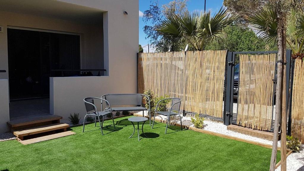 d'un jardin avec des chaises, une table et une clôture. dans l'établissement Perra, à Sérignan