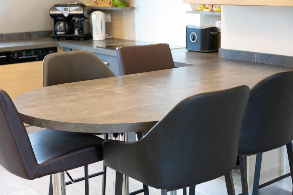 una mesa de madera y sillas en la cocina en Appartement 100m2 Vilvic vue mer, en Trégunc