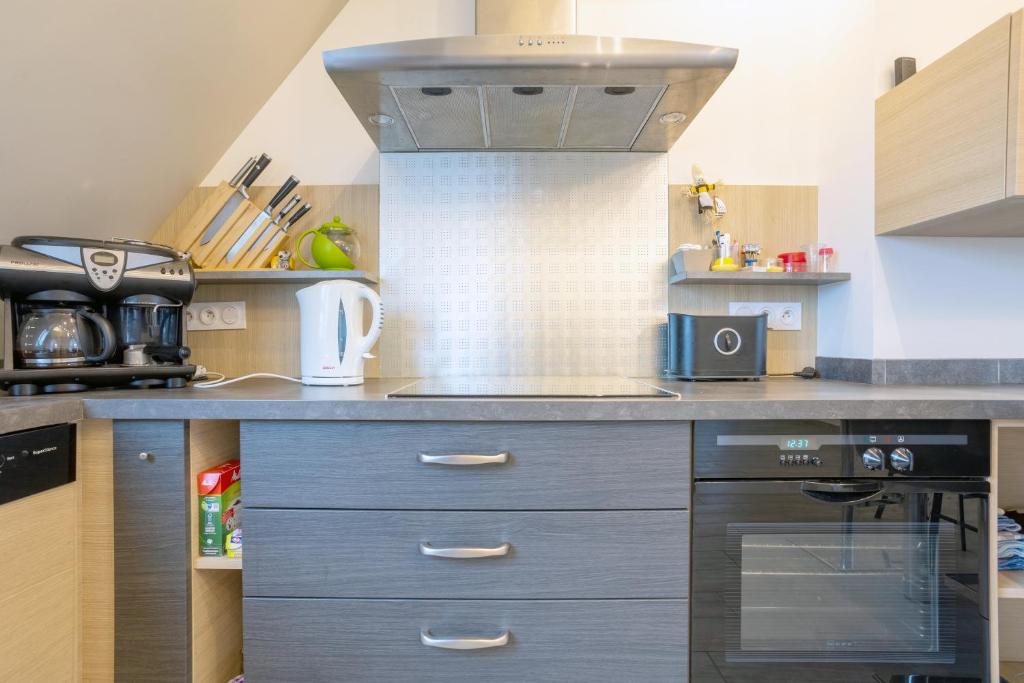 cocina con fregadero y fogones horno superior en Appartement 100m2 Vilvic vue mer, en Trégunc