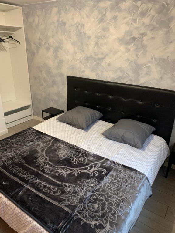 a bedroom with a large bed with a black headboard at Appartement équipé pour 5 pers in Vénissieux
